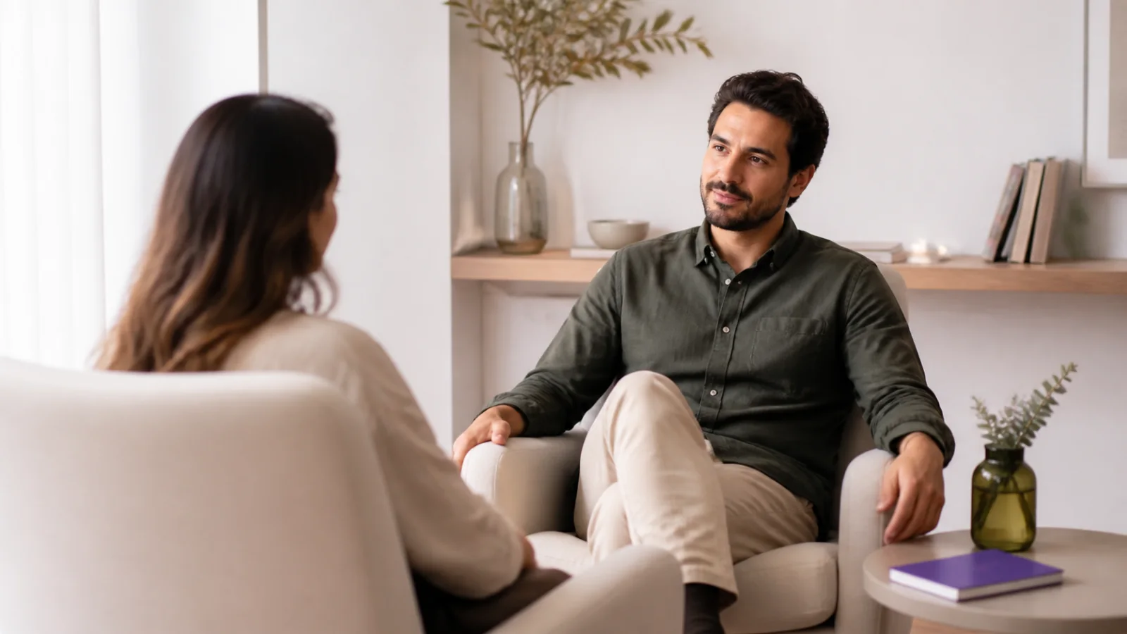 Duas pessoas adultas conversando em poltronas em um ambiente acolhedor